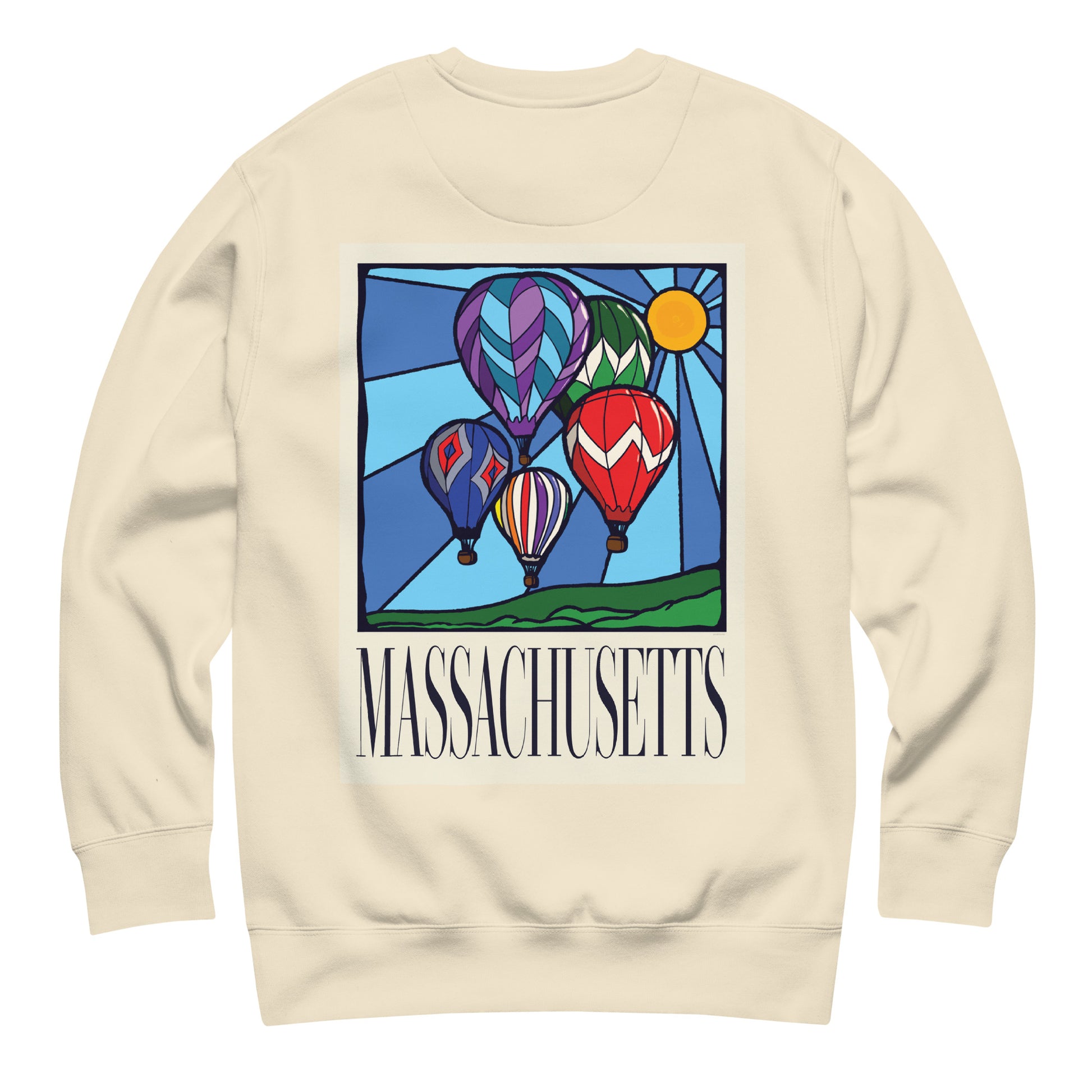 Bone colored Massachusetts sweatshirt laid flat, back view showing a large hand-drawn illustration of colorful hot air balloons and a bright sun over green hills, with the word ‘Massachusetts’ in serif font in Navy print below.